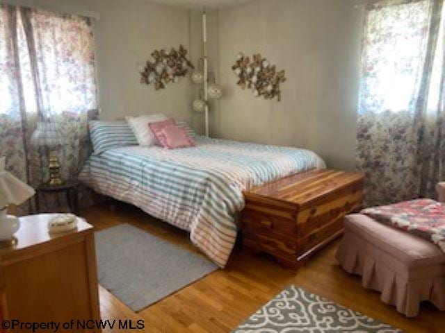 bedroom with hardwood / wood-style flooring and multiple windows