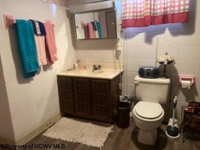 bathroom featuring tile walls, toilet, and vanity