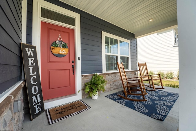 view of exterior entry featuring covered porch