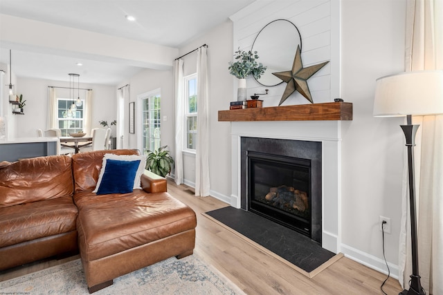 living room with a large fireplace and light hardwood / wood-style floors