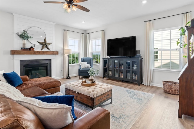 living room featuring ceiling fan and light hardwood / wood-style flooring