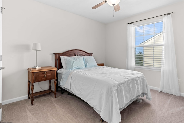 carpeted bedroom featuring ceiling fan and multiple windows