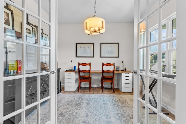 home office featuring hardwood / wood-style floors and an inviting chandelier