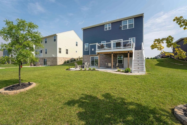 rear view of house with a wooden deck, a patio, and a yard