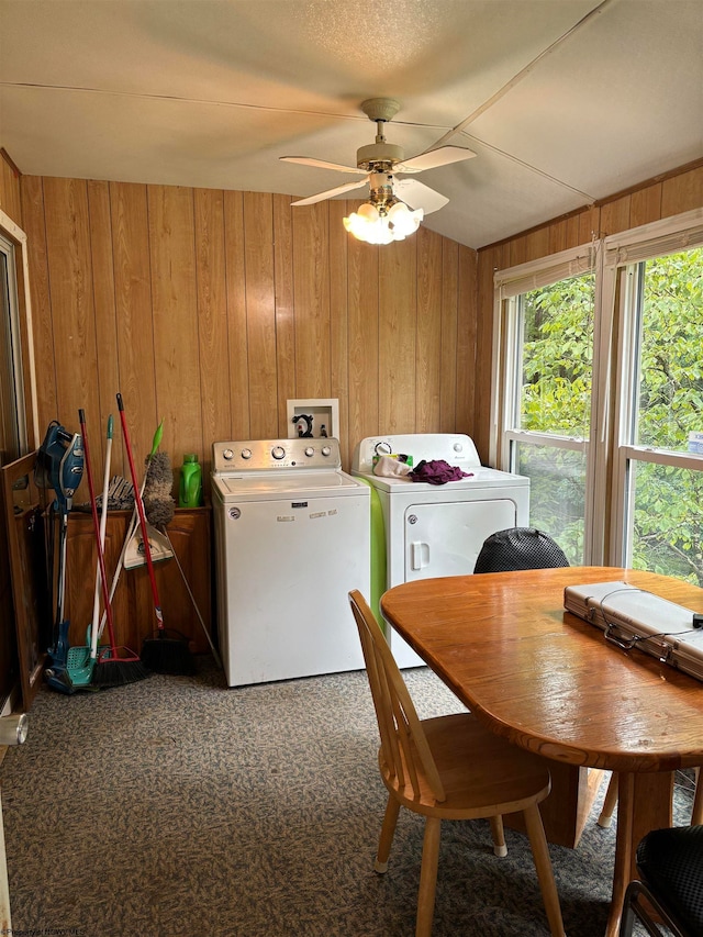 laundry area with ceiling fan, wooden walls, washing machine and clothes dryer, and carpet