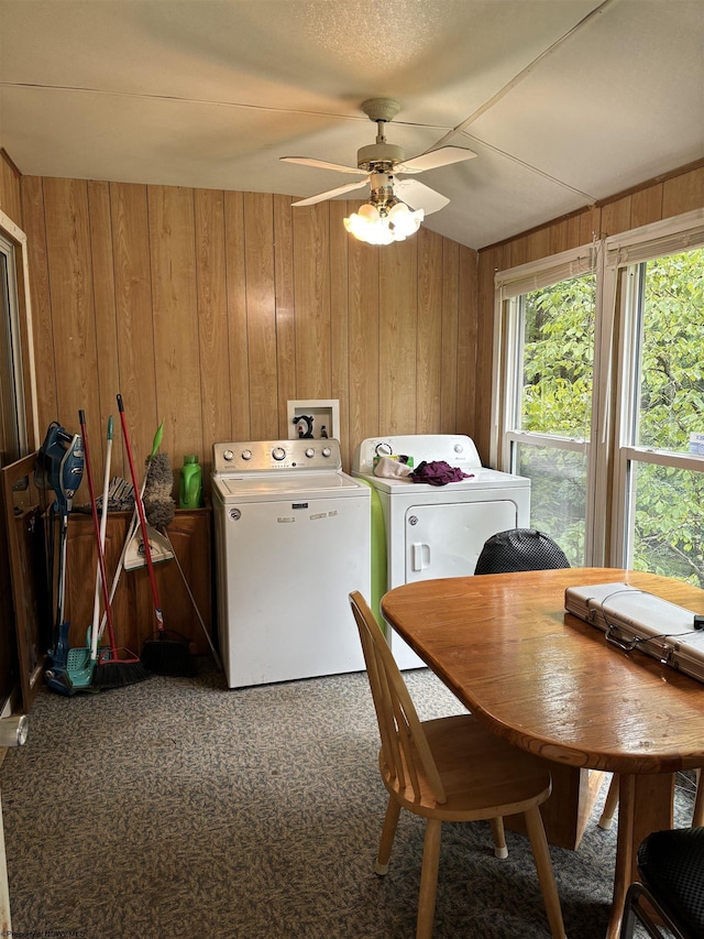 dining space with washing machine and clothes dryer, carpet floors, ceiling fan, and wood walls