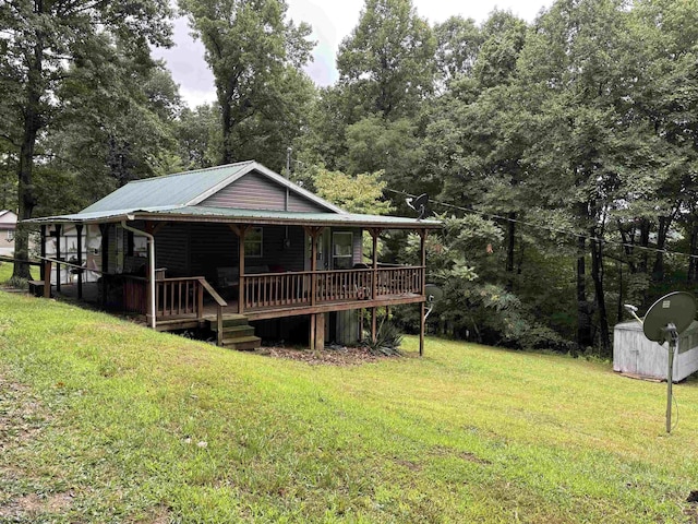view of front facade featuring a front lawn, metal roof, and covered porch