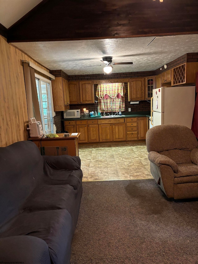 tiled living room featuring ceiling fan, sink, and a textured ceiling