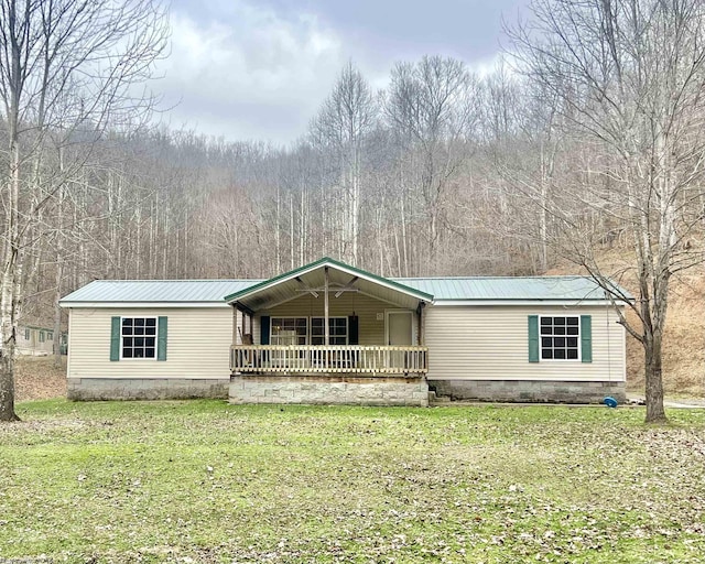 manufactured / mobile home featuring a porch and a front lawn