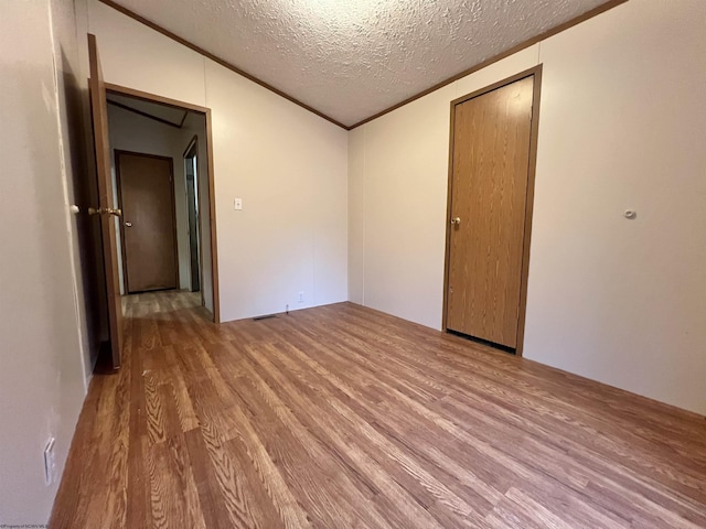 unfurnished room with ornamental molding, light hardwood / wood-style flooring, and a textured ceiling