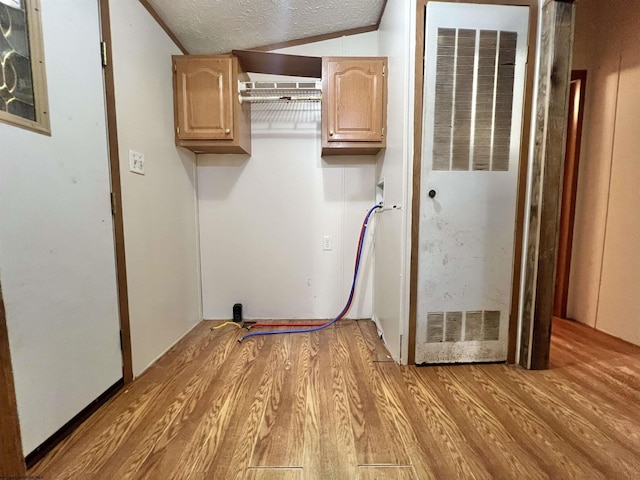 laundry area featuring a textured ceiling and light wood-type flooring