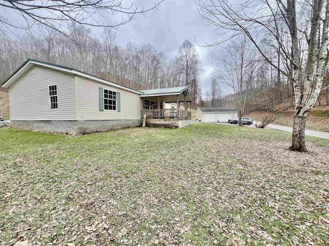 view of side of home featuring a yard and covered porch