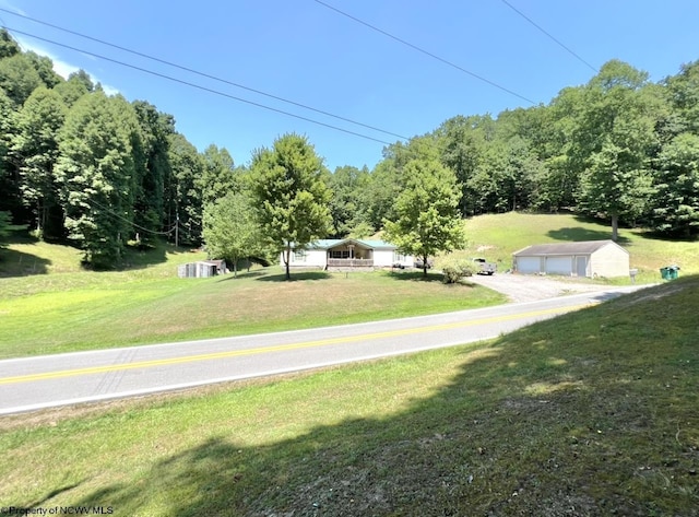 view of yard featuring a garage and an outbuilding