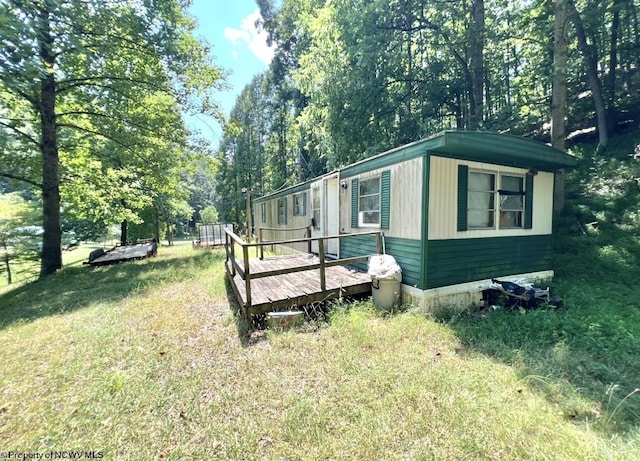 view of property exterior with a wooden deck and a yard