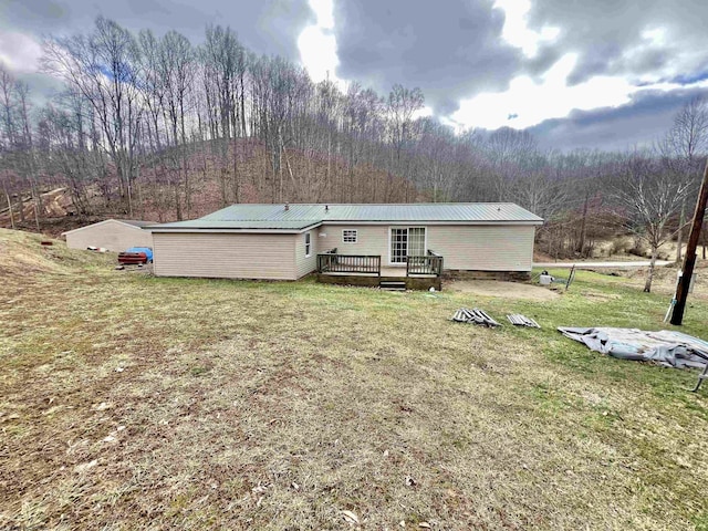 back of house with a wooden deck and a lawn