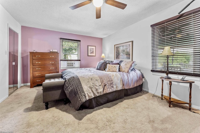 bedroom with a ceiling fan, baseboards, a textured ceiling, and light colored carpet