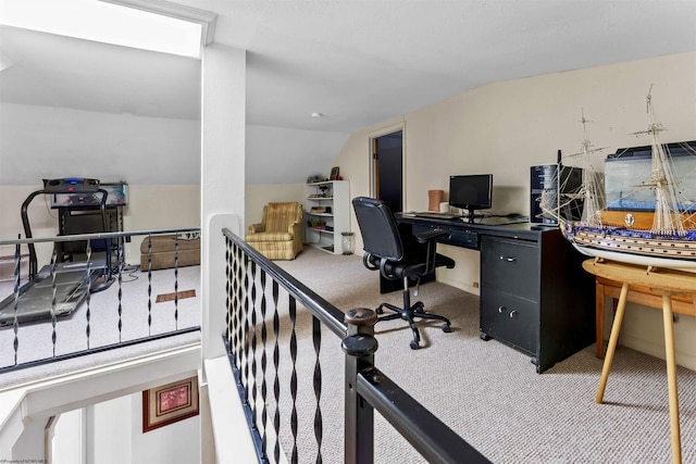 carpeted home office featuring lofted ceiling