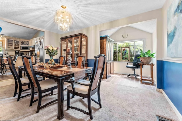 dining space with light carpet, vaulted ceiling, a textured ceiling, and visible vents