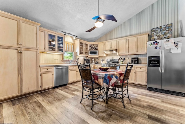 kitchen with stainless steel appliances, light brown cabinets, glass insert cabinets, and under cabinet range hood