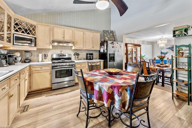 kitchen featuring under cabinet range hood, stainless steel appliances, light countertops, light wood-type flooring, and light brown cabinetry