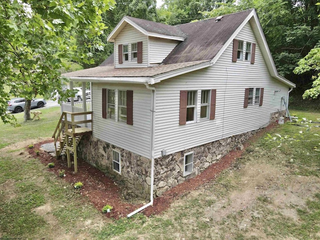 view of side of home featuring roof with shingles