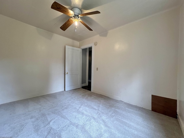 spare room featuring light carpet, ceiling fan, and ornamental molding