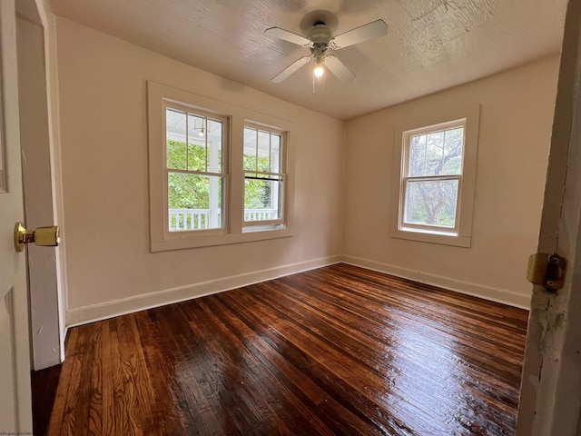 unfurnished room featuring dark wood-style floors, a textured ceiling, a ceiling fan, and baseboards