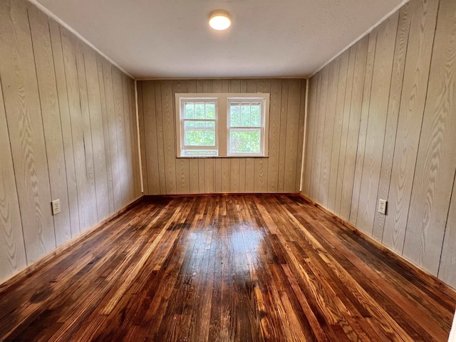 empty room featuring wood-type flooring and wood walls