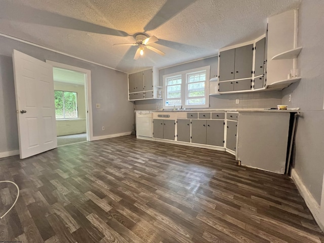 kitchen featuring plenty of natural light, open shelves, white dishwasher, and dark wood finished floors