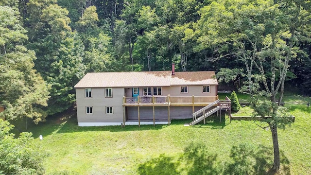 back of house with a deck and a lawn