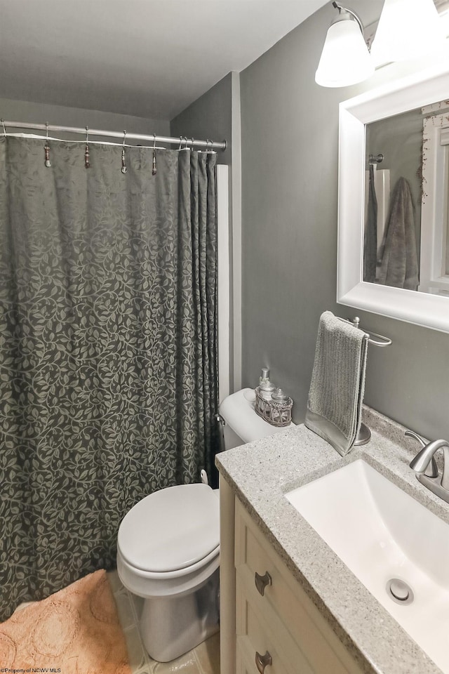 bathroom with toilet, tile patterned floors, and vanity