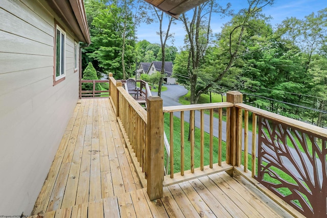 wooden terrace featuring a lawn