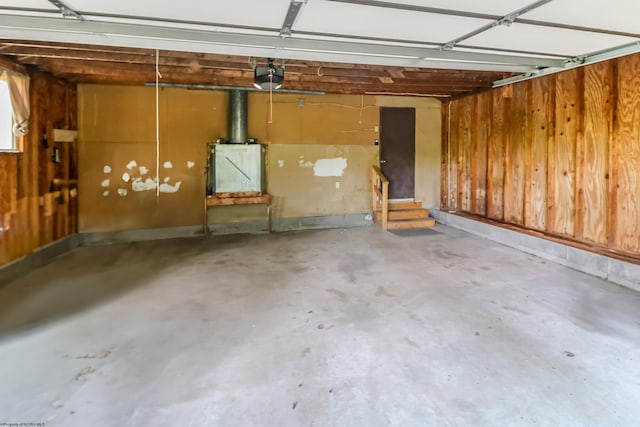 garage featuring a garage door opener and wooden walls