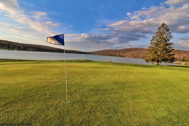 view of property's community featuring a lawn and a water view