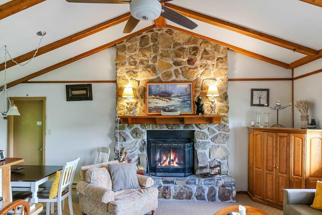 carpeted living room with a stone fireplace, lofted ceiling with beams, and ceiling fan