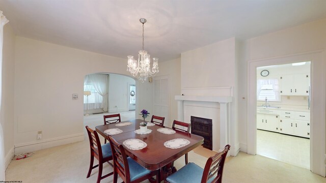 carpeted dining room featuring sink and an inviting chandelier