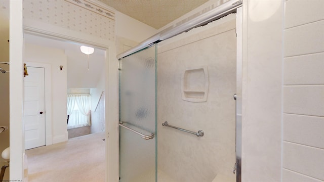 bathroom with a textured ceiling and a shower with door