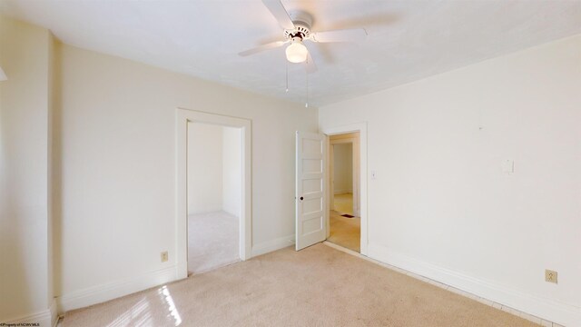 unfurnished bedroom with ceiling fan and light carpet