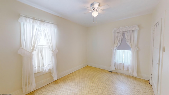 tiled empty room featuring ceiling fan