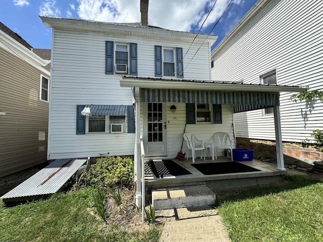 rear view of property featuring a lawn