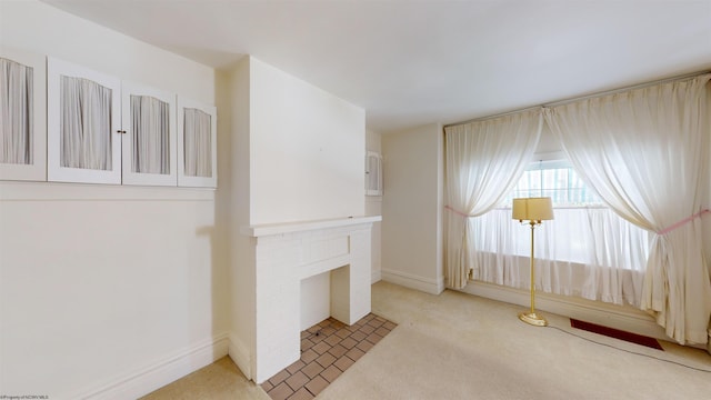 interior space with a fireplace and light colored carpet