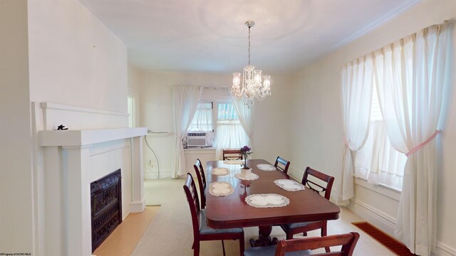 carpeted dining area featuring cooling unit and a chandelier