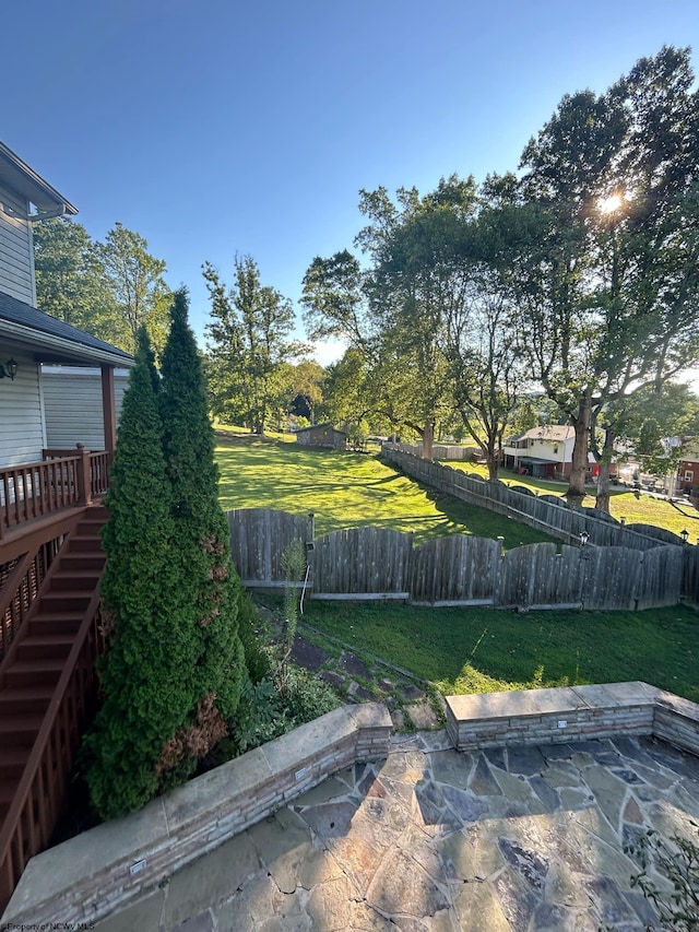 view of yard with a wooden deck and a patio