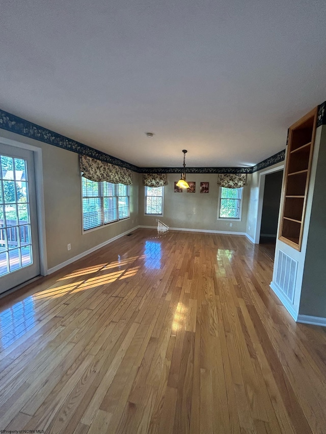 unfurnished living room featuring wood-type flooring and plenty of natural light