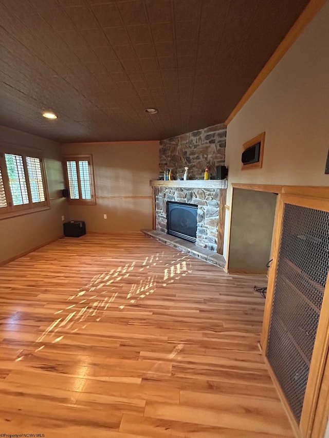 unfurnished living room with a stone fireplace and light hardwood / wood-style floors