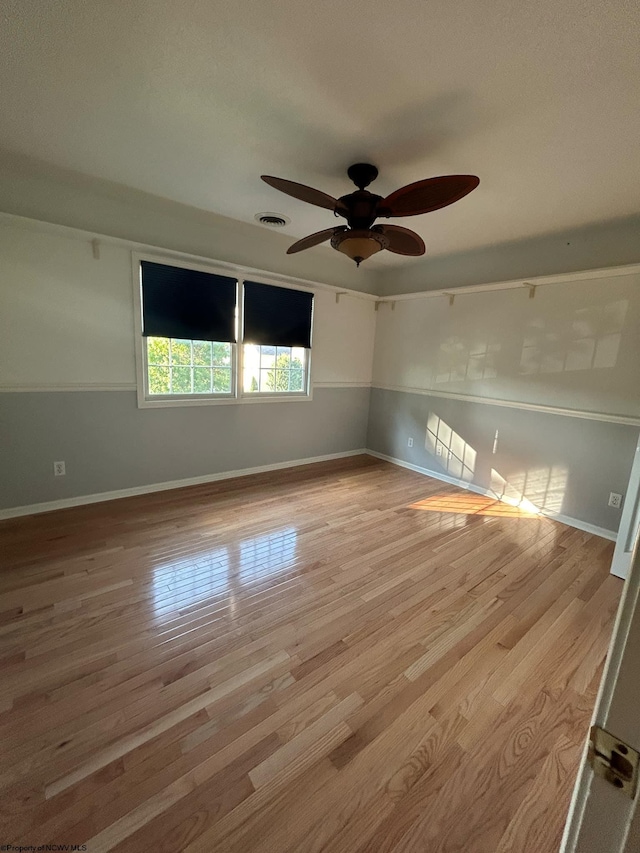 empty room with ceiling fan and light hardwood / wood-style floors