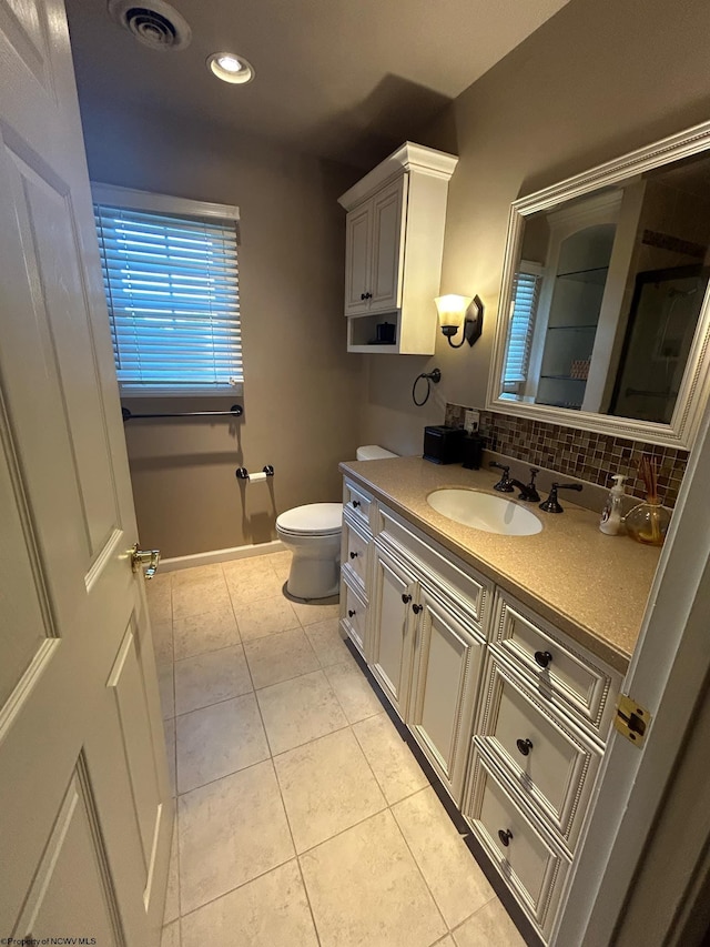 bathroom featuring decorative backsplash, tile patterned floors, vanity, and toilet