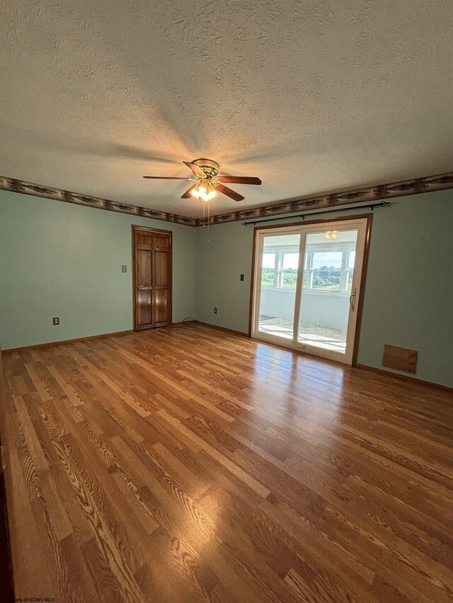 spare room with a textured ceiling, hardwood / wood-style floors, and ceiling fan