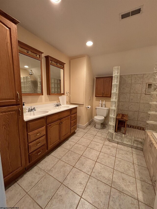 bathroom with double sink vanity, toilet, tile patterned floors, and a bidet