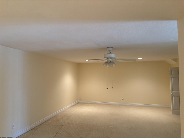 empty room featuring ceiling fan and light carpet